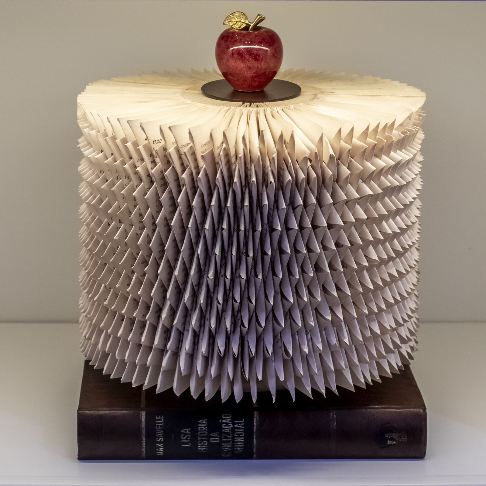 Inspiração: obra de livros dobrados com maçã vermelha